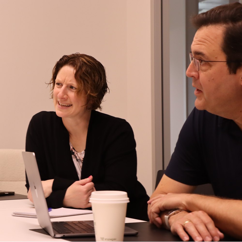 Two people in conversation across a meeting table